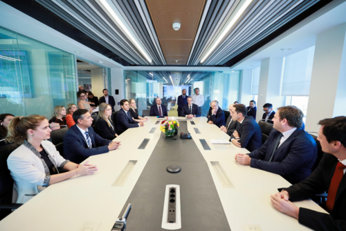 Business meeting with professionals seated around a long table in a modern conference room.